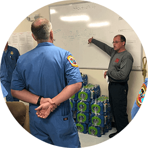 Emergency manager at white board explaining plan to response team